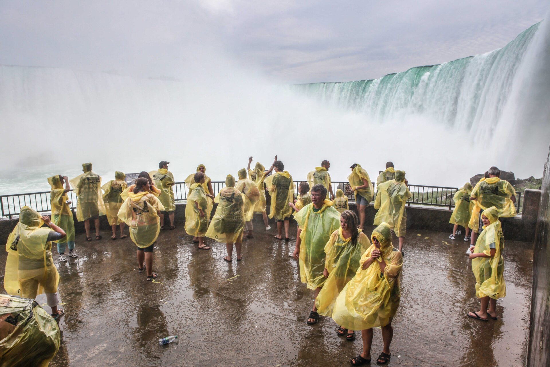 Tourists enjoying the splash from the majestic Niagara Falls