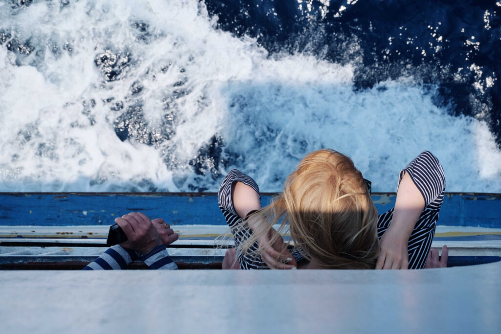 A child leaning from a boat
